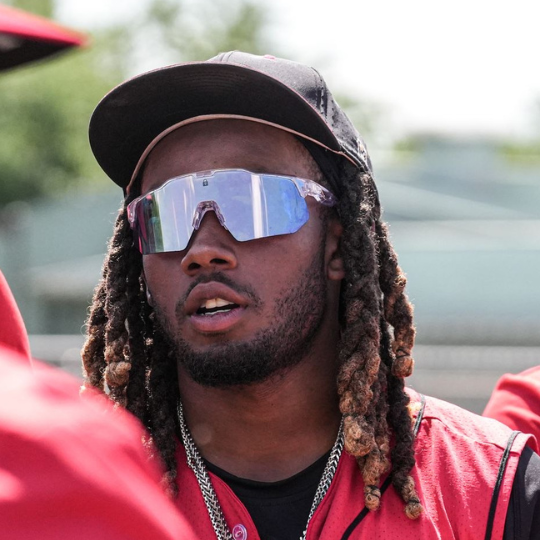 Professional baseball player wearing PA10 polarized sunglasses on the field during a sunny game, showcasing UV400 lens clarity and pro-fit wraparound frame