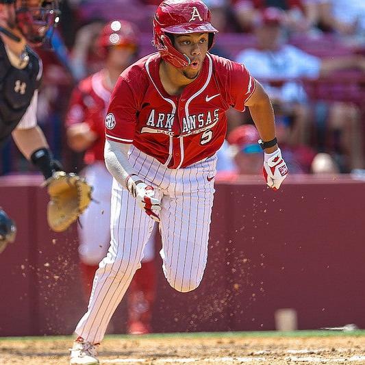 Image of Kendall Diggs Captian for Arkansas Baseball team #5. Diggs is running out of the box after a hard-hit baseball. He is in full Arkansas Razorback baseball uniform and wearing Locked Eyewear.