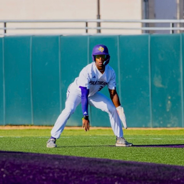 Baseball player holding bat wearing performance baseball sunglasses for glare reduction