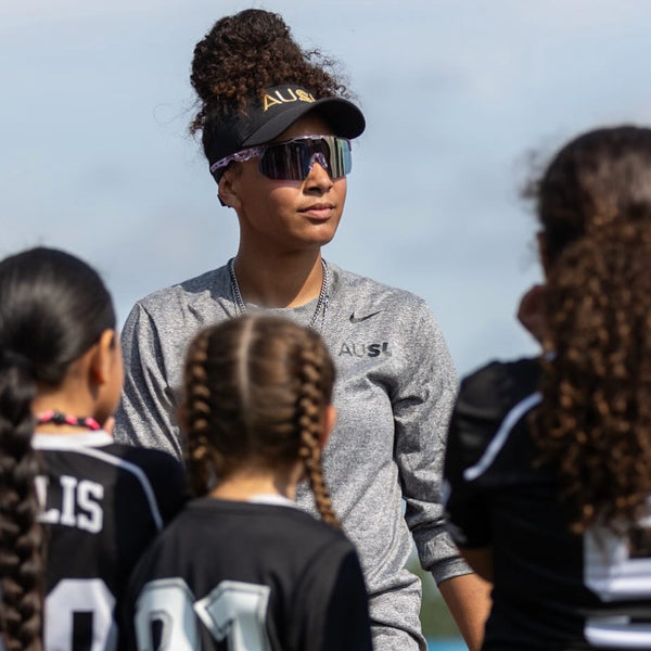 Professional softball player tracking fly balls wearing lightweight baseball sunglasses.