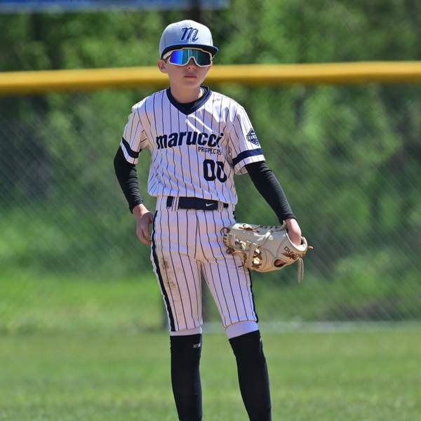 Travel ball athlete wearing sunglasses playing the field