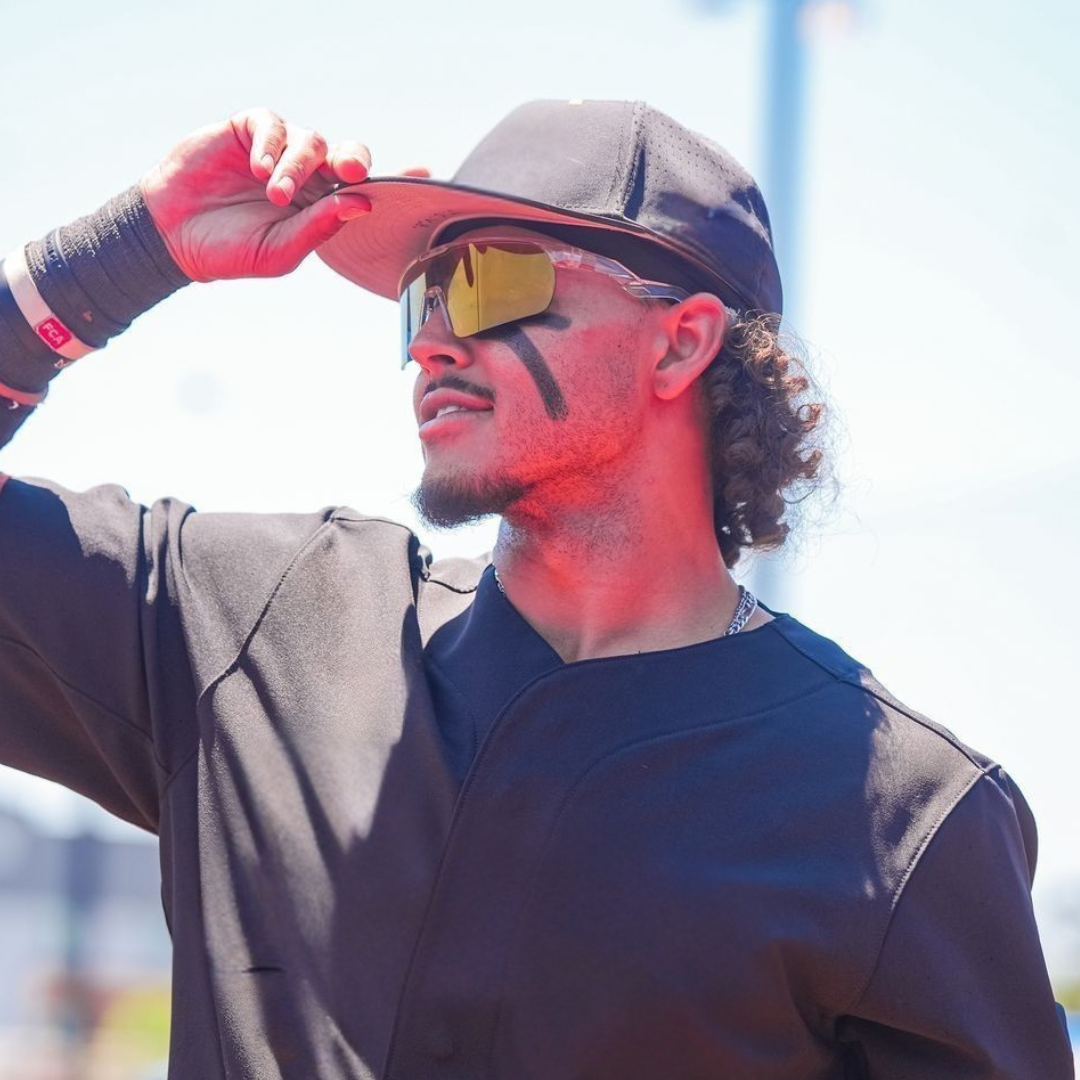 Locked Eyewear Revelation gold lens baseball sunglasses worn by an outfielder tracking a fly ball in game, the reflective non-polarized shield cutting glare for a clean read under bright sun